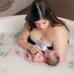 new mother bottle feeding newborn in a milk bath